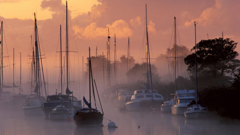Boats in misty harbor at dawn