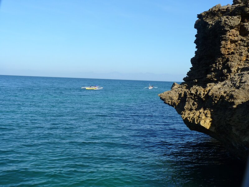 Boats near rocky coastline