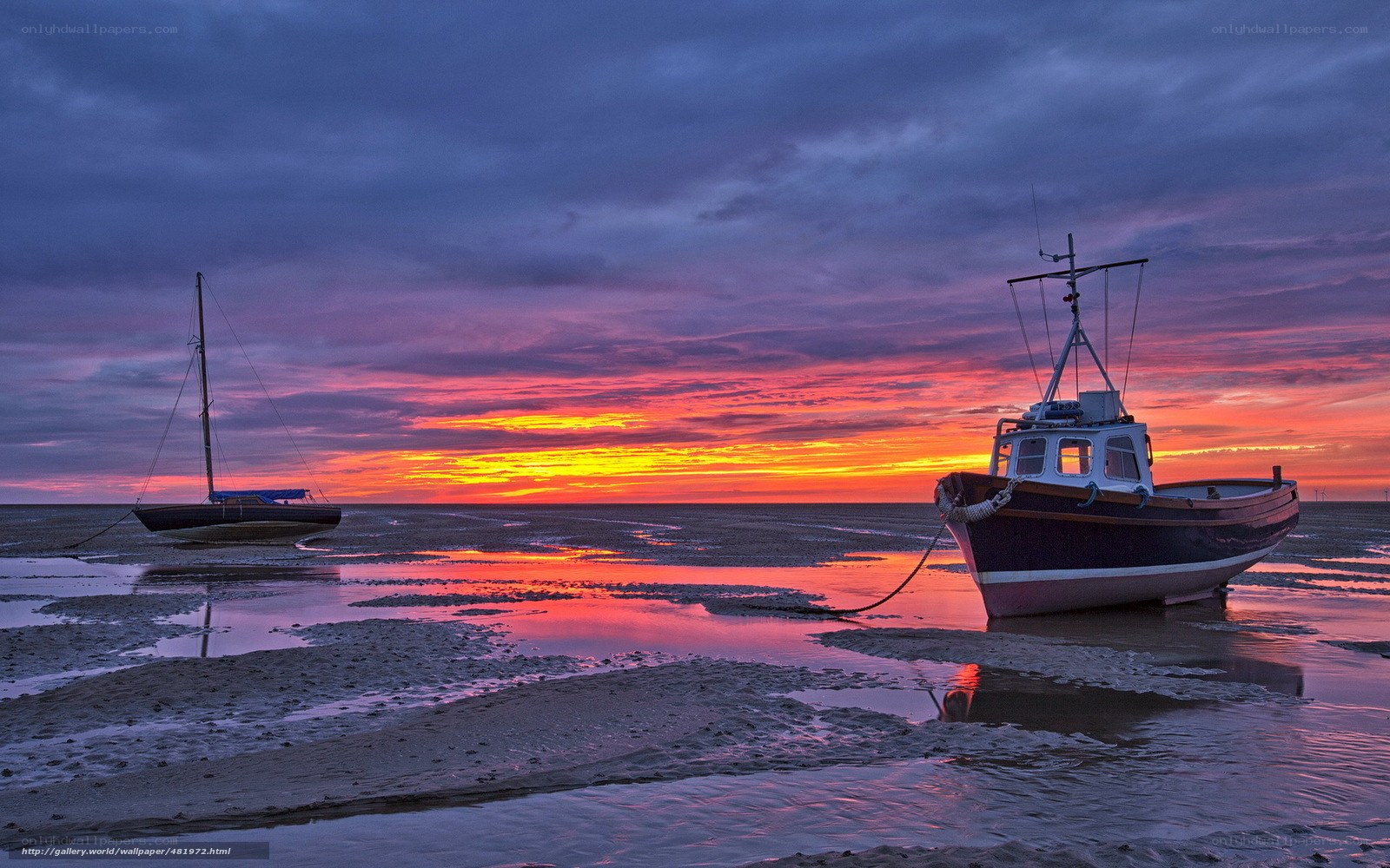 Boats on a beach at sunset