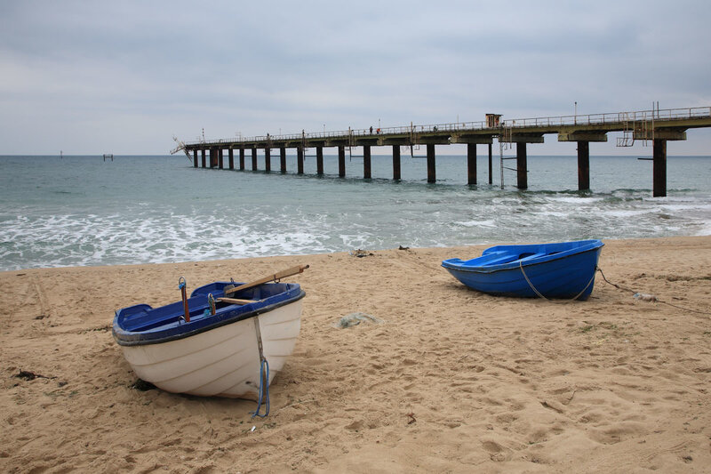 Boats on a beach with pier