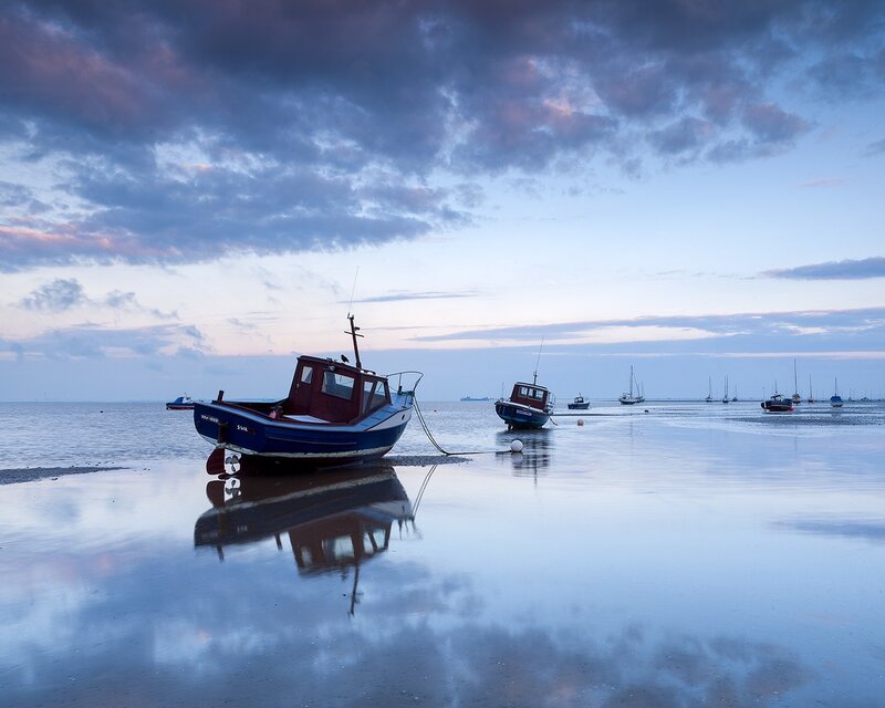 Boats on a calm beach at dusk