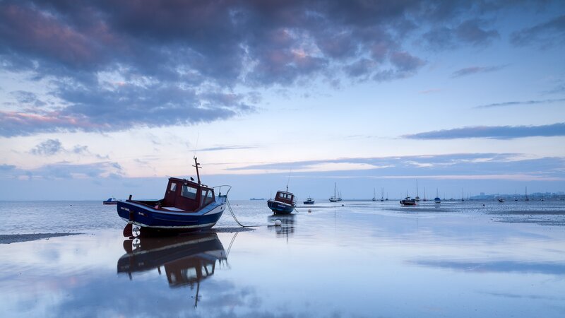 Boats on a calm beach at dusk