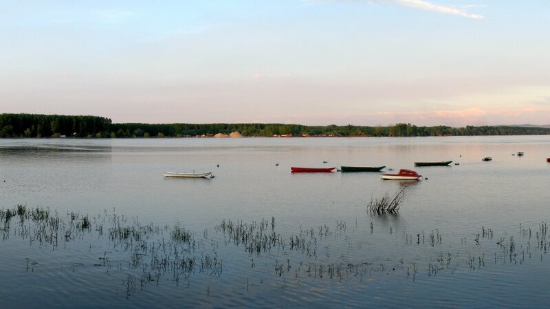 Boats on a calm lake at dusk