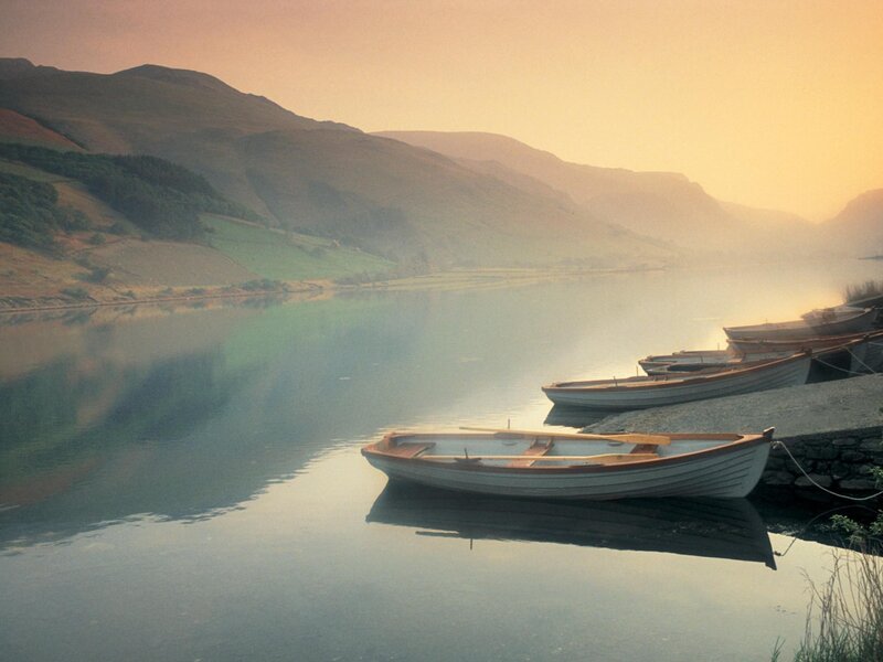 Boats on a calm lake at sunrise