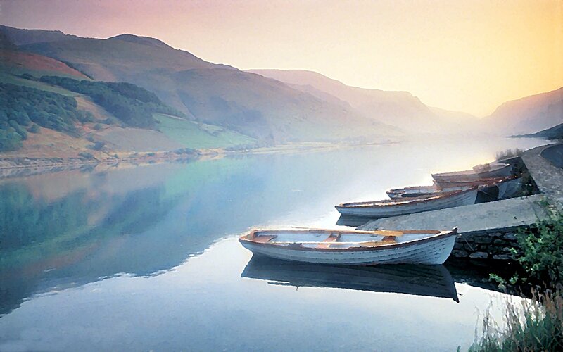 Boats on a calm lake at sunrise