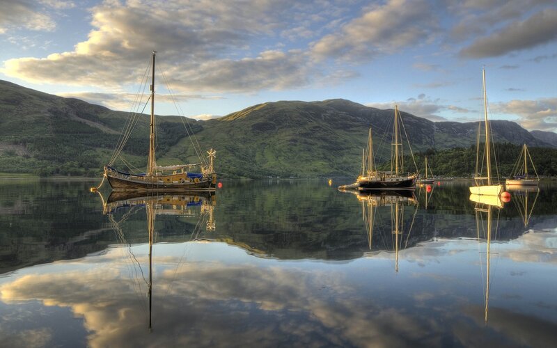 Boats on a calm lake at sunset