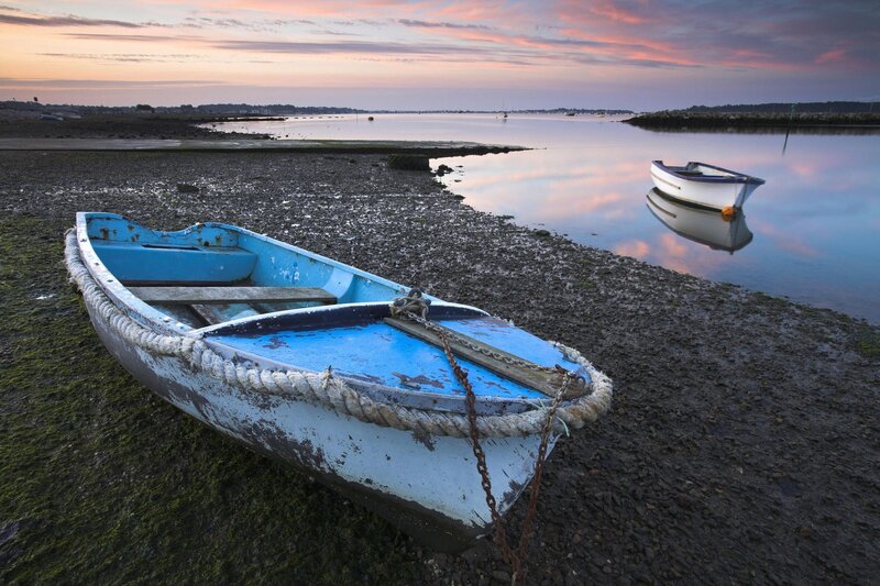 Boats on a calm shore at sunset