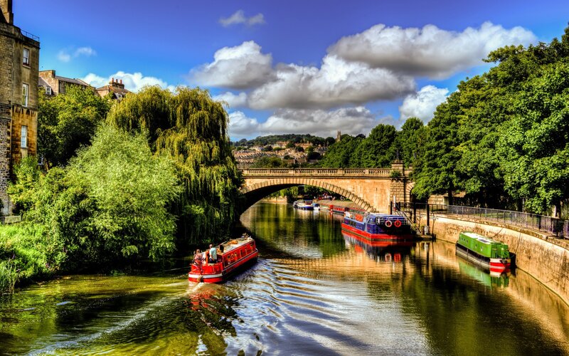 Boats on a canal under a stone bridge