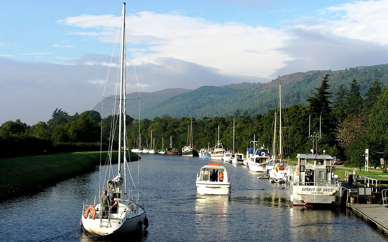 Boats on a canal with mountains