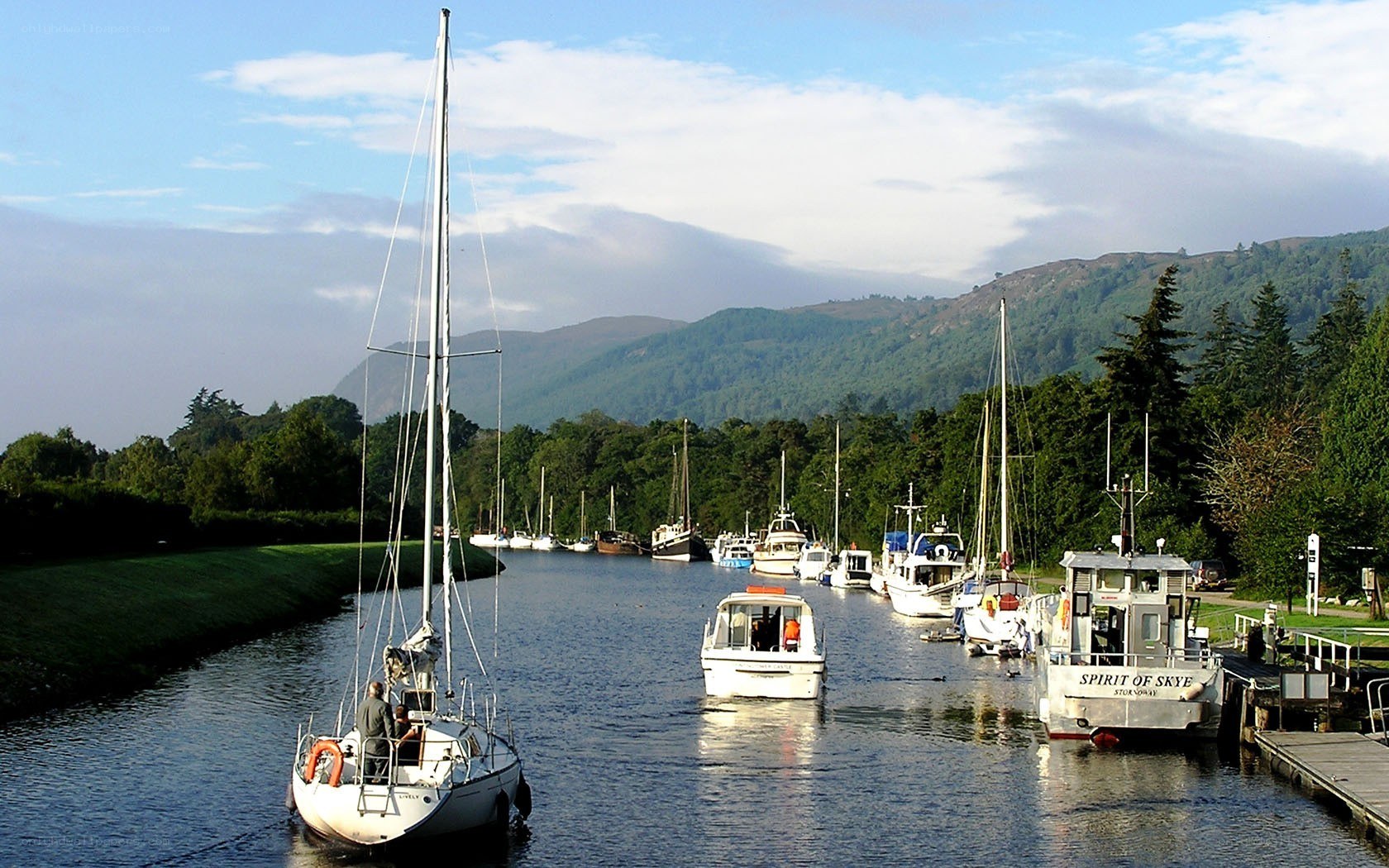 Boats on a canal with mountains