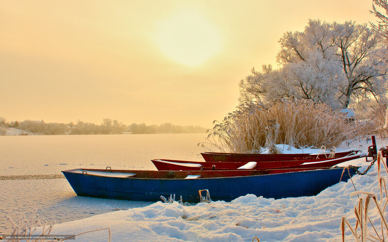Boats on a frozen lake at sunset