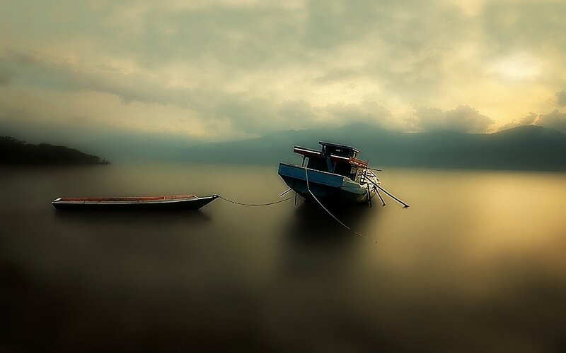 Boats on a misty lake at dawn