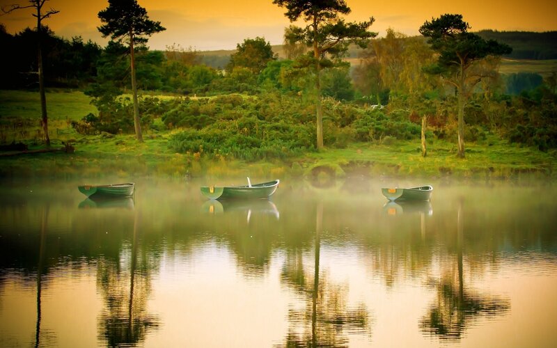 Boats on a misty lake at dawn
