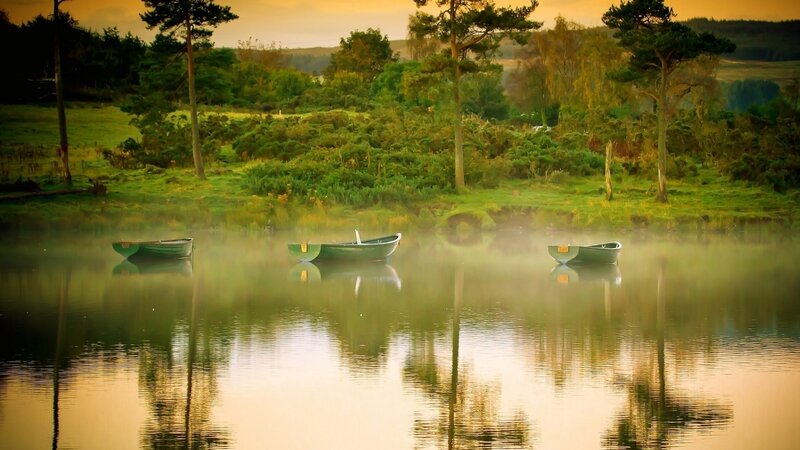 Boats on a misty lake at dawn