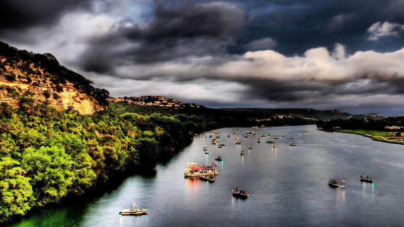 Boats on a river under stormy sky