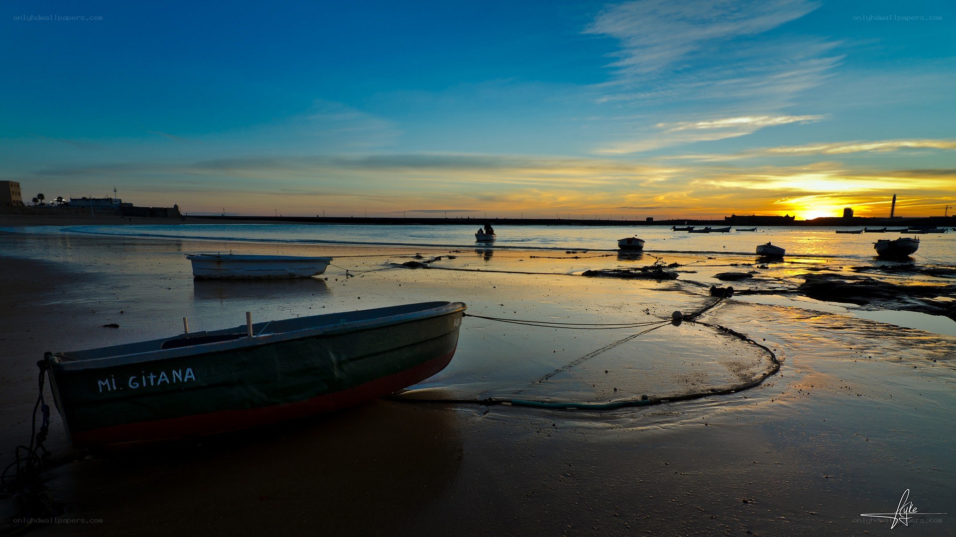 Boats on beach at sunset