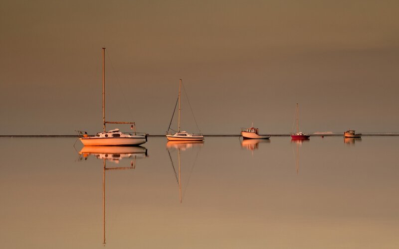 Boats on calm water at sunset