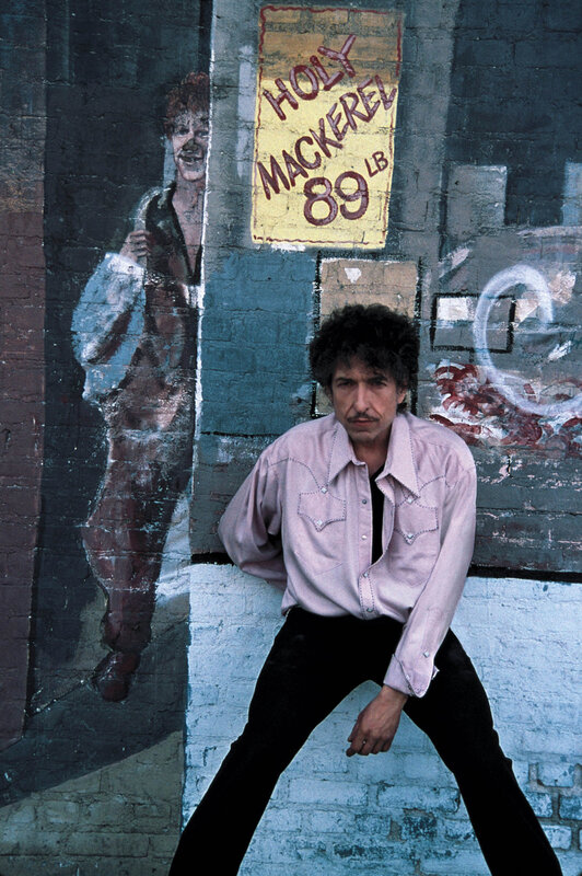 Bob Dylan in front of graffiti wall