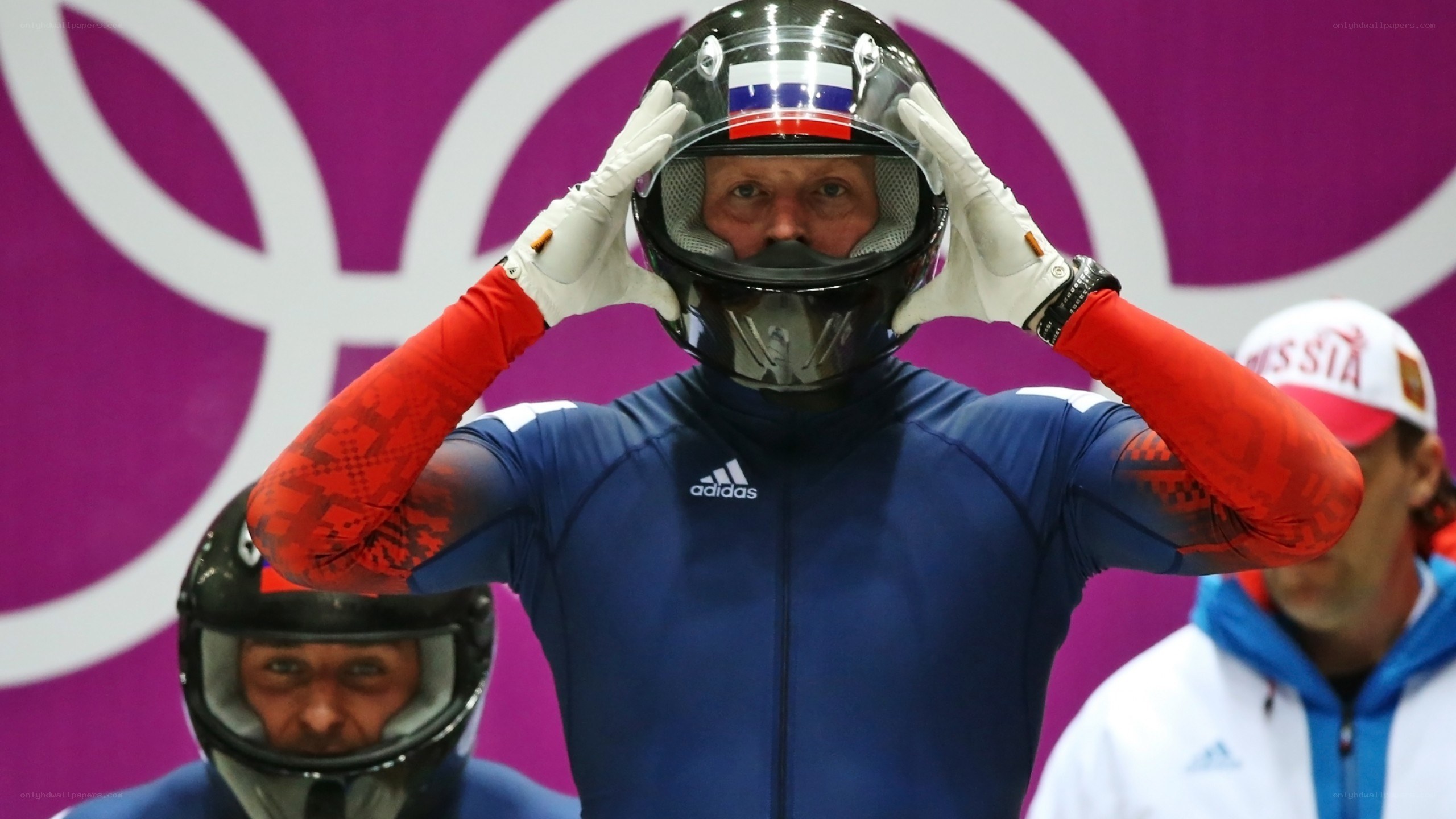 Bobsledder adjusting helmet