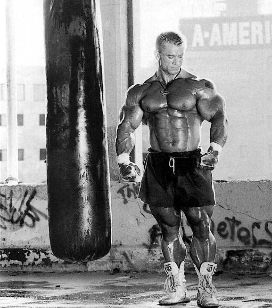 bodybuilder posing with punching bag