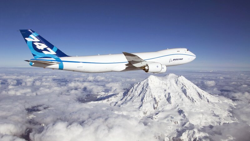 Boeing 747 flying over mountain