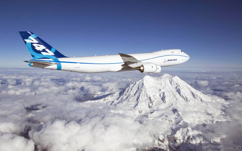 Boeing 747 flying over mountain