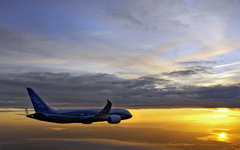 Boeing 787 in flight at sunset