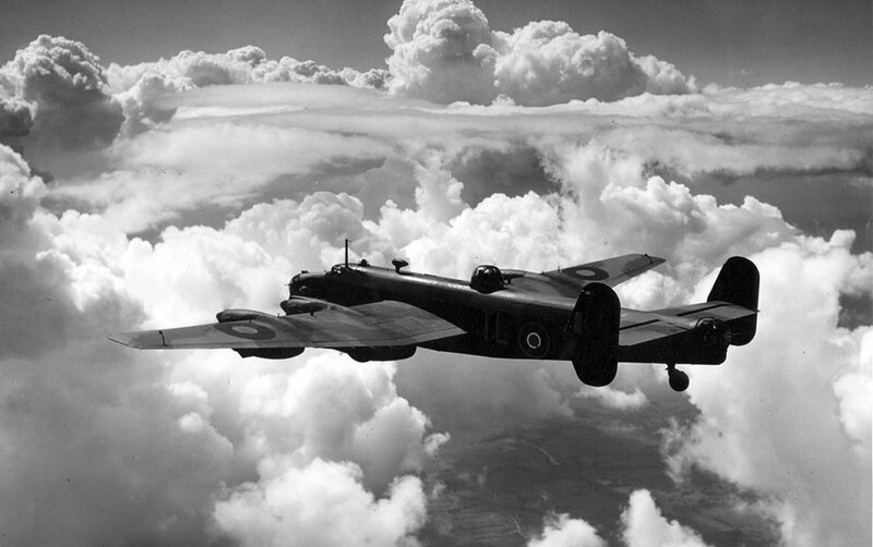 Bomber aircraft flying above clouds