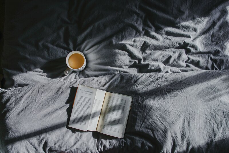 Book and coffee on a bed