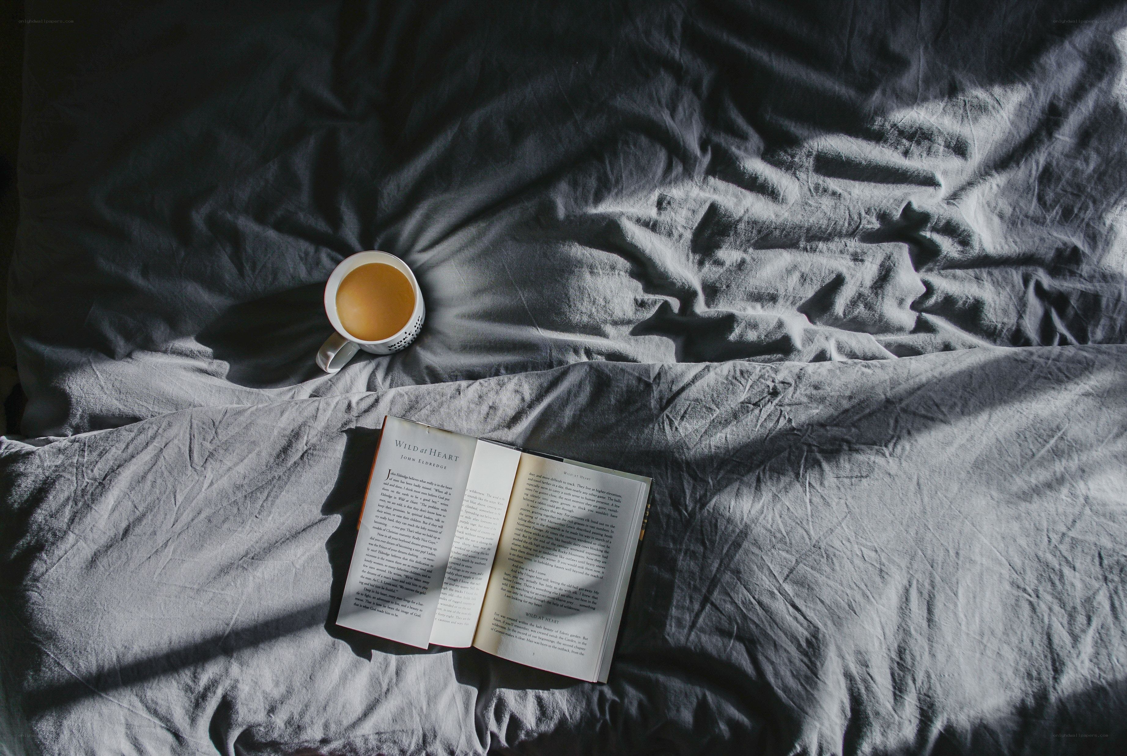 Book and coffee on a bed