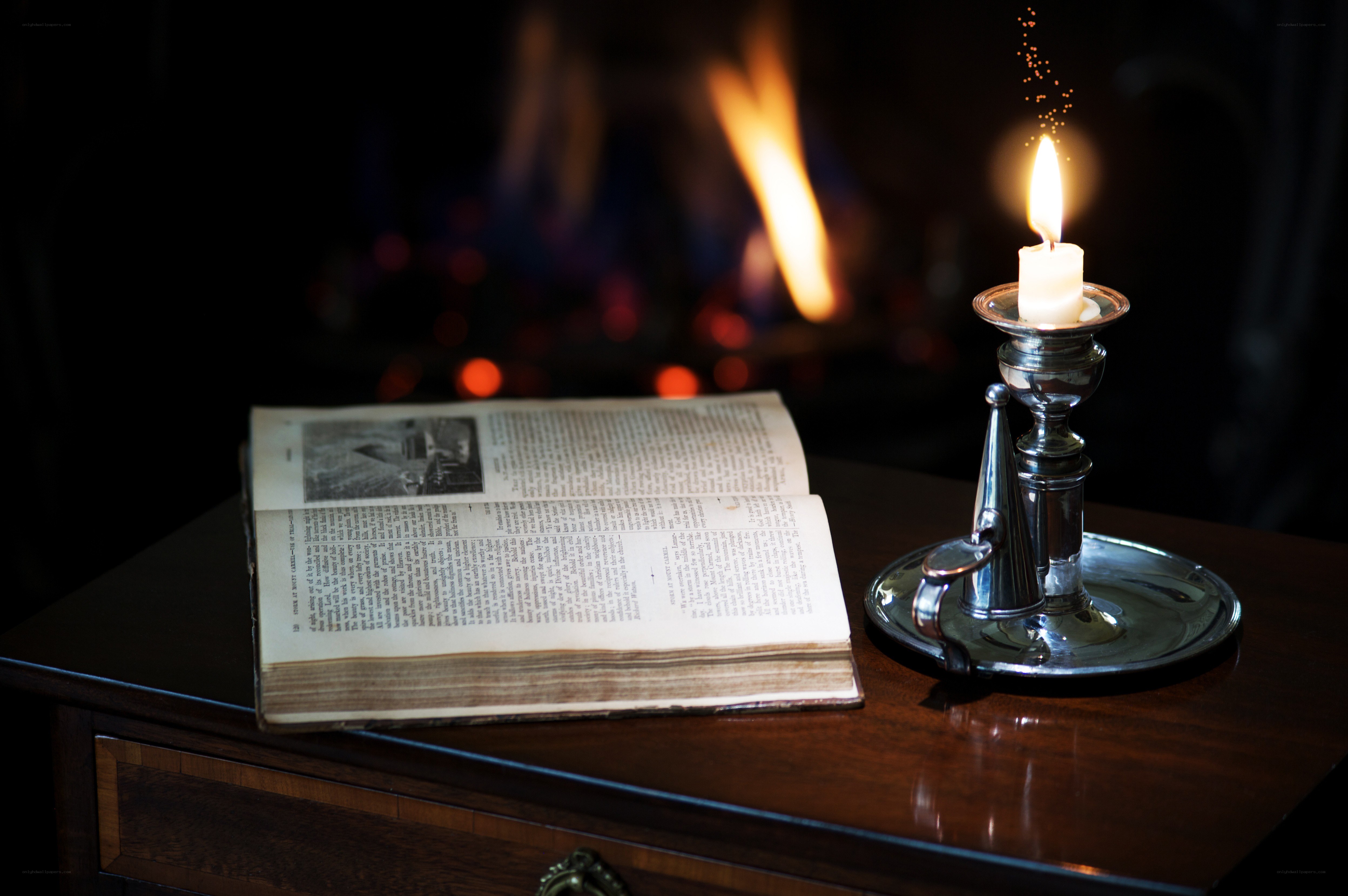 Book by candlelight near fireplace