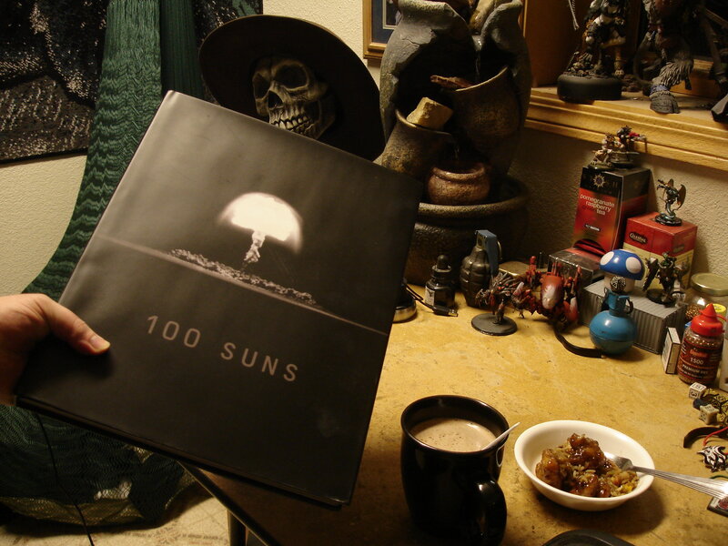 Book titled '100 Suns' on a cluttered desk