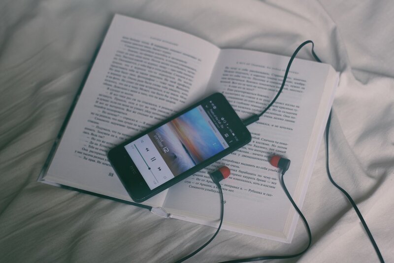 book with phone and earbuds
