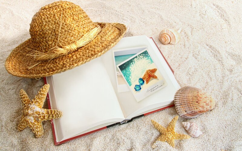 Book with Seashells on Sand
