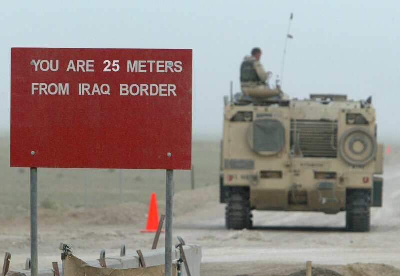 Border sign near military vehicle