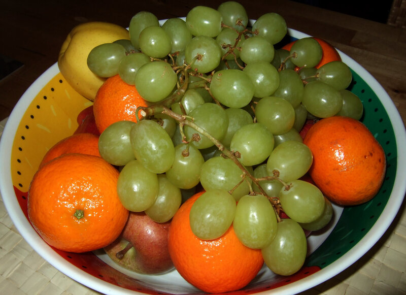 bowl of fruit with grapes and oranges
