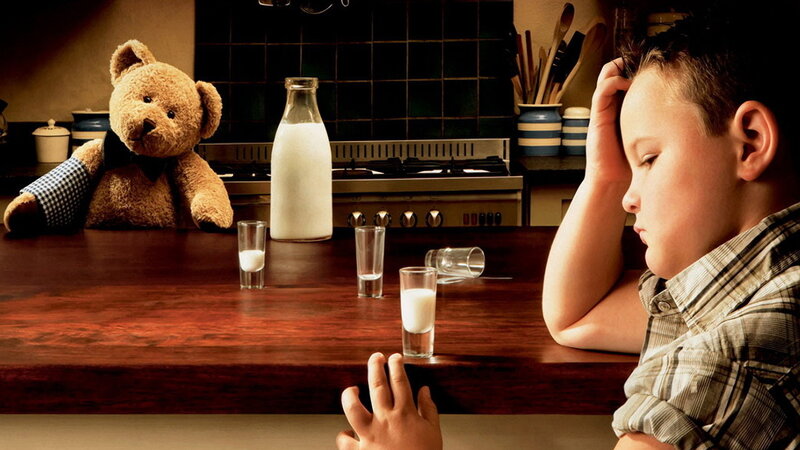 Boy and teddy bear at kitchen table