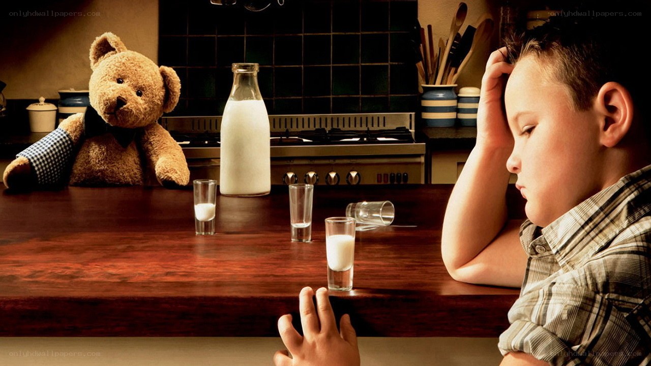Boy and teddy bear at kitchen table