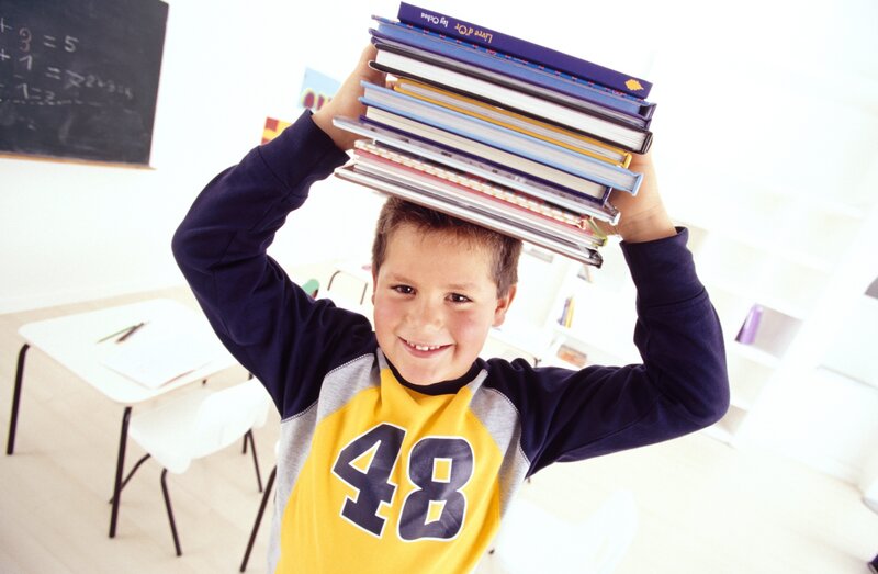 Boy balancing books on head