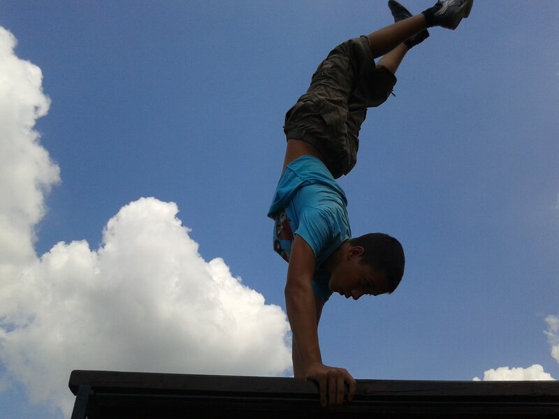 Boy doing handstand on bench