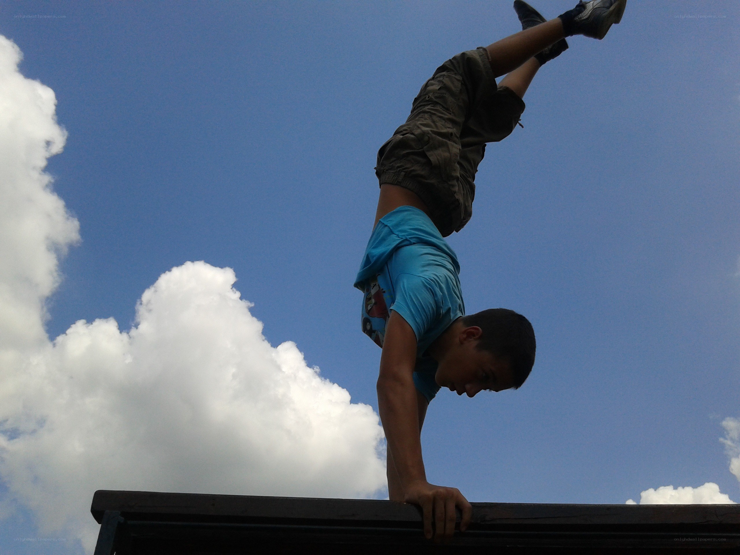 Boy doing handstand on bench