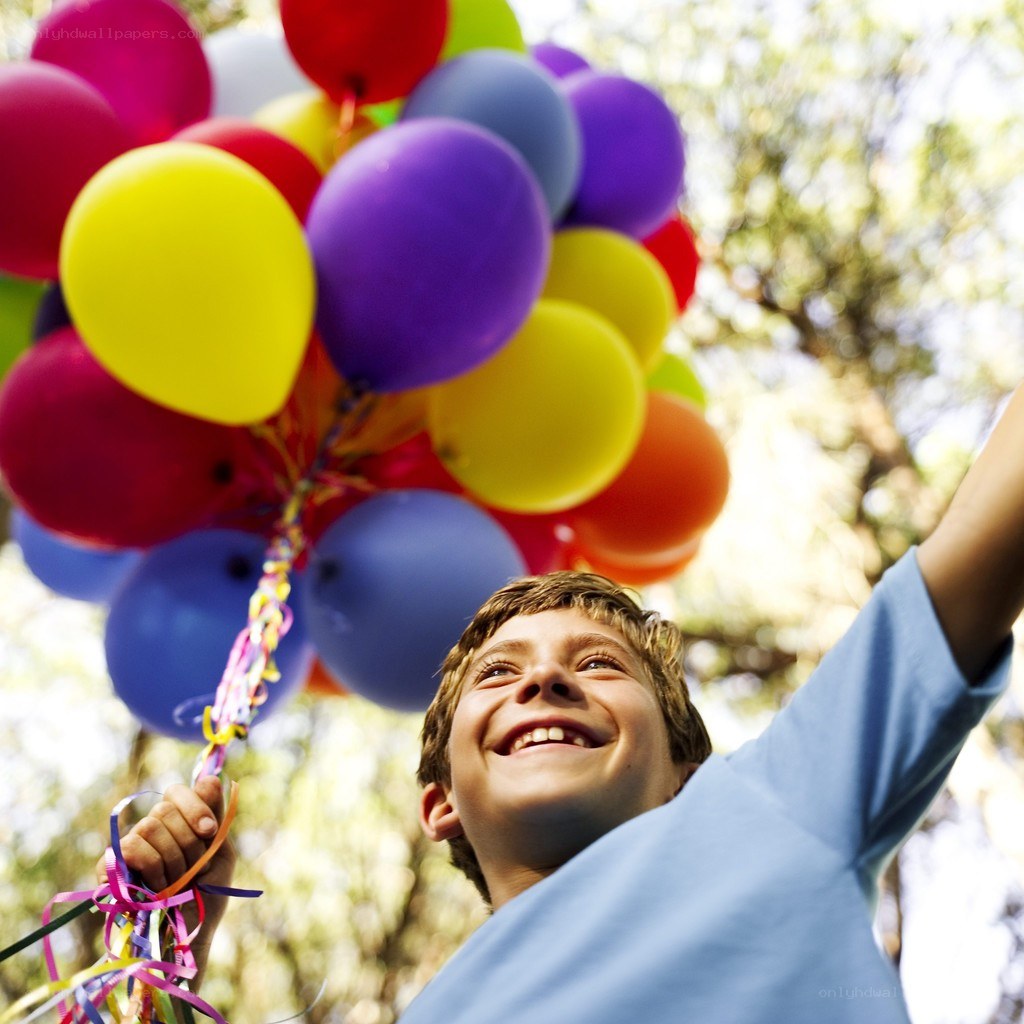 boy holding colorful balloons