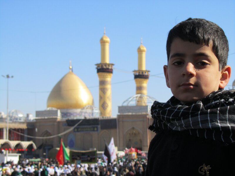 Boy in front of golden mosque
