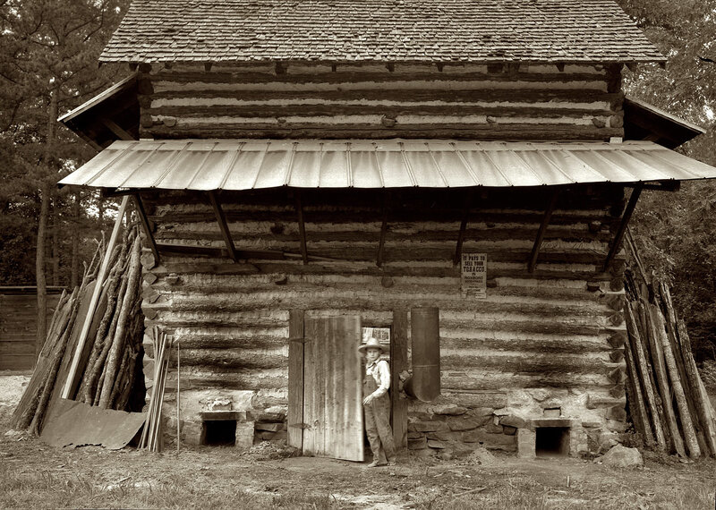 Boy in front of log cabin