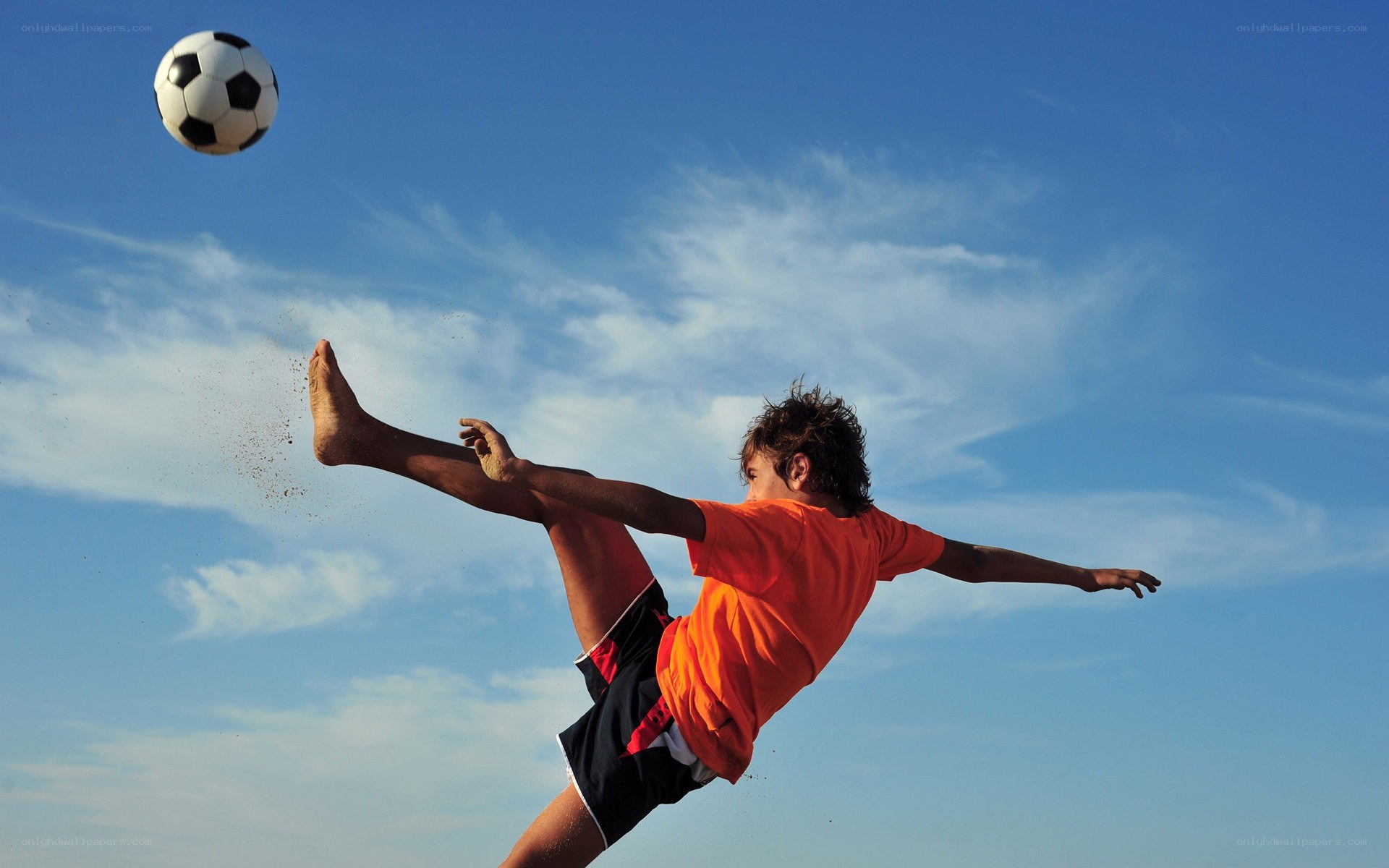 boy kicking soccer ball
