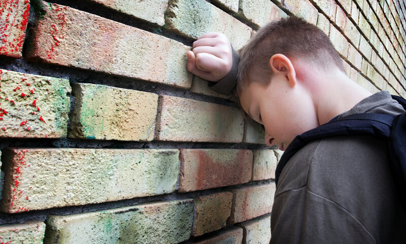 Boy Leaning Against Brick Wall