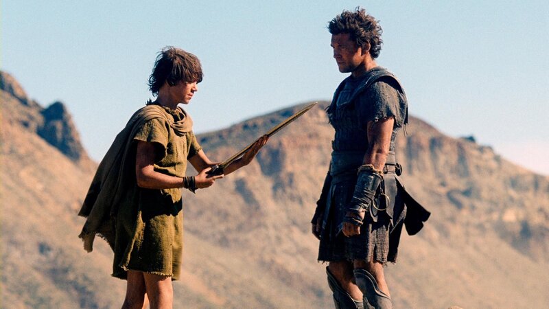 boy offering sword to warrior