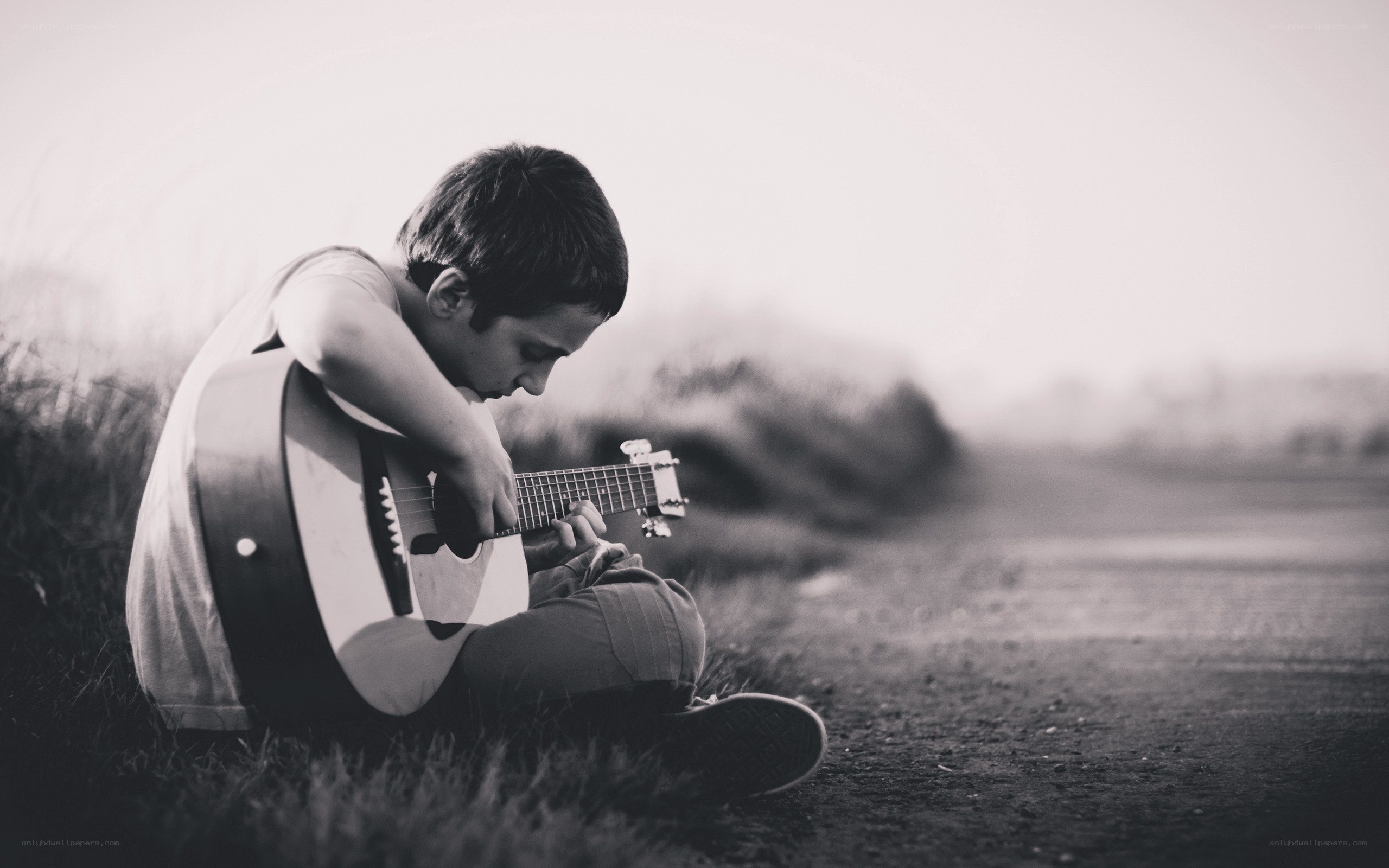boy playing guitar on road