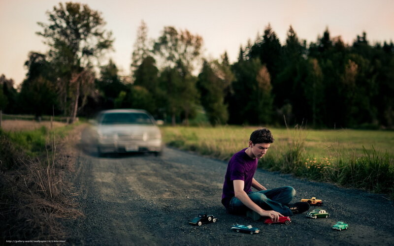 Boy playing with toy cars on road