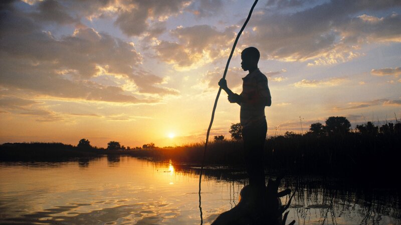 Boy silhouetted at sunset